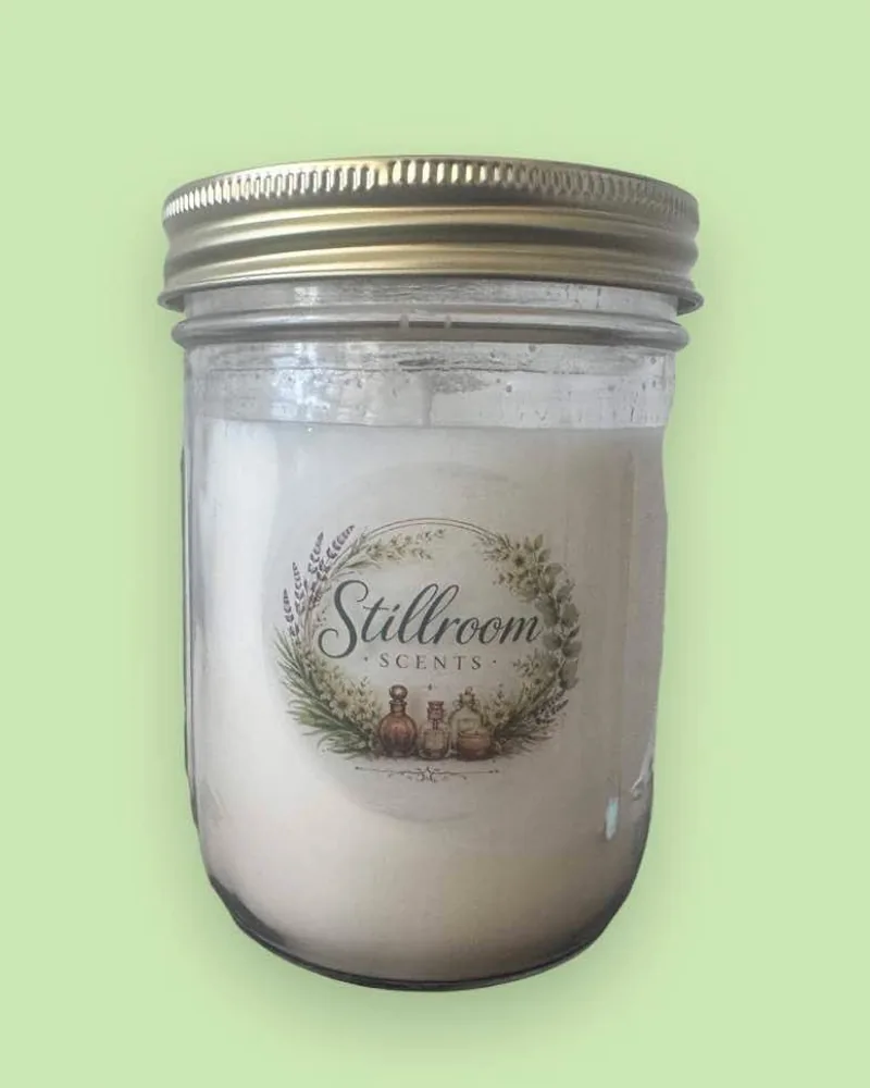 Stillroom Scents 16 oz candle in a clear jar with a gold lid