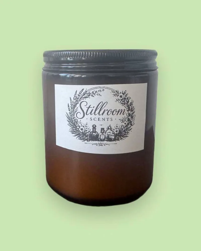 Stillroom Scents 8 oz candle in an amber jar with a black lid