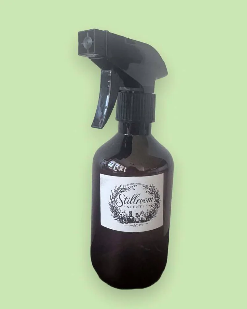 Stillroom Scents room spray in an amber bottle with a black trigger sprayer